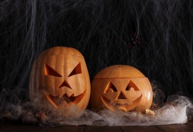 Örümcek ağında iki cadılar bayramı kabağı örümceği ve sonbahar yapraklarıyla