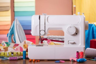 İşyeri terzileri, beyaz elektrikli daktilo, çok renkli kumaşlar ve aksesuarlar.