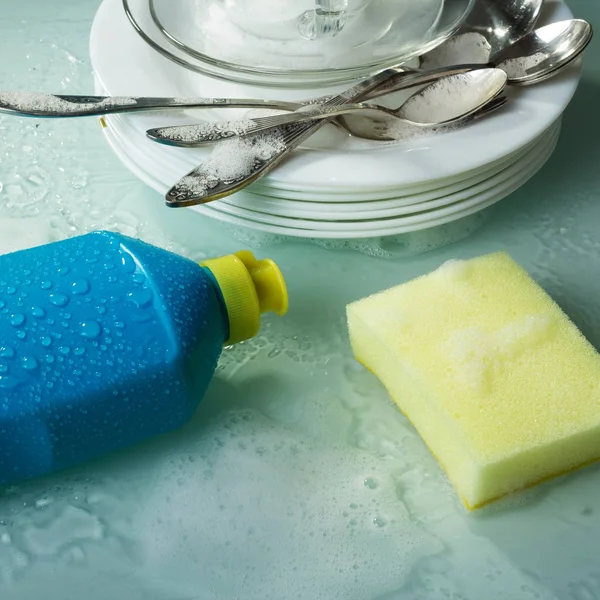 Washing dishes with special tool, yellow sponge and plates in the foam — Stock Photo, Image