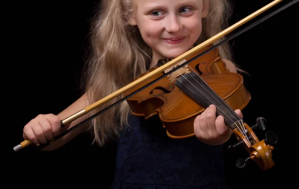 Блондинка маленькая девочка учится играть на скрипке изолированы на черном — стоковое фото