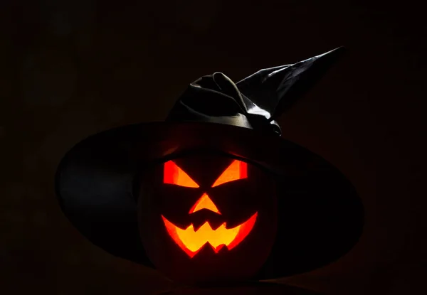 Зловісний Джек О ліхтар Хелловін з капелюхом-відьмами на чорному тлі. — стокове фото