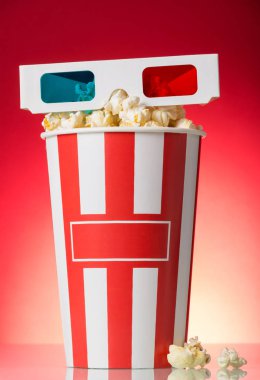 3D gözlükler, kutu patlamış mısır ve birkaç tane de parlak kırmızı gözlük..