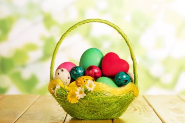 Sepette Paskalya yumurtaları ve soyut yeşilde kırmızı kalp..