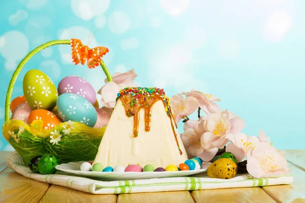 Traditional Easter cheesecake dessert, easter eggs, candy, flowers, towel on abstract blue. — Stock Photo, Image