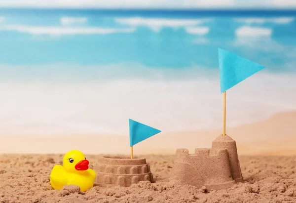 Coliseu e Torre de areia, bandeira azul, pato de borracha na praia . — Fotografia de Stock