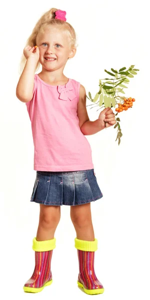 Cheerful little girl in blouse, skirt and rubber boots holding b — Stock Photo, Image