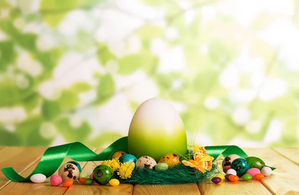 Ostereier im Nest und als nächstes Süßigkeiten, ein großer Schmetterling. — Stockfoto