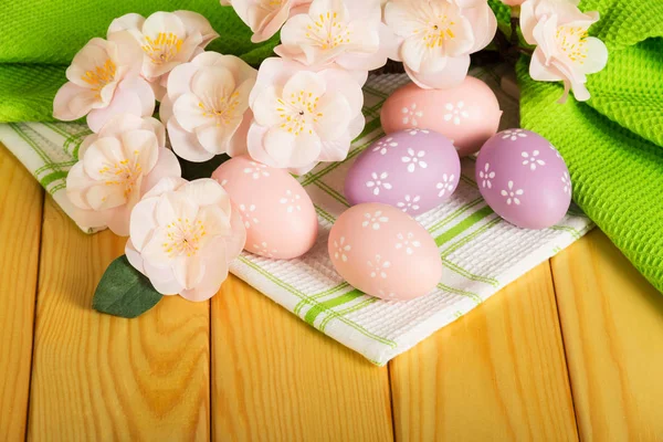 Färgade påskägg, gren blommor på bakgrund grön bomull t — Stockfoto