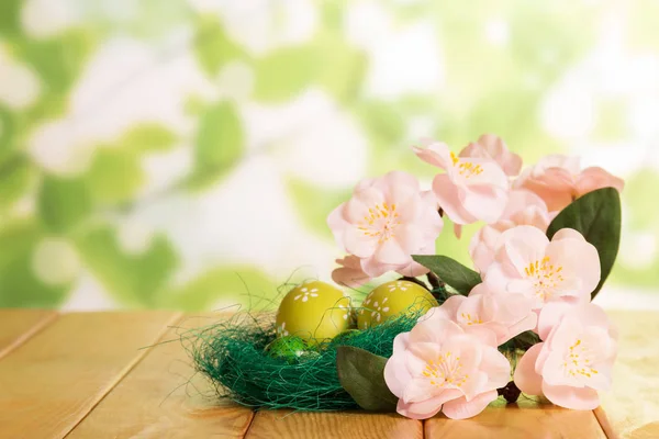 Are different Easter eggs in nest and branch with flowers. — Stock Photo, Image