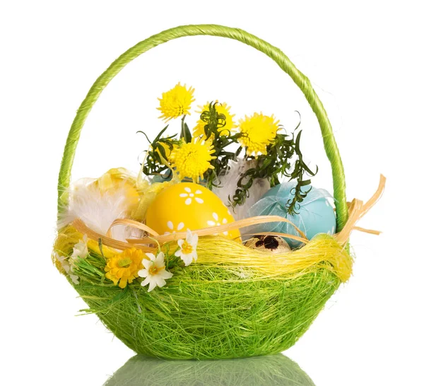Basket with Easter eggs, grass and flowers, isolated on white. — Stock Photo, Image