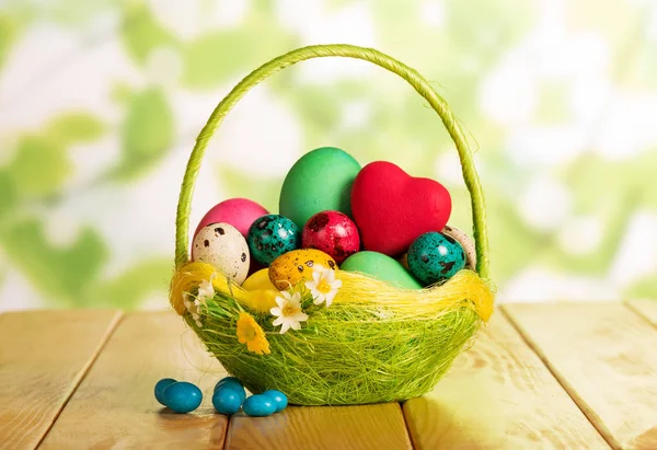 Easter eggs in basket, heart and candy on abstract green. — ストック写真