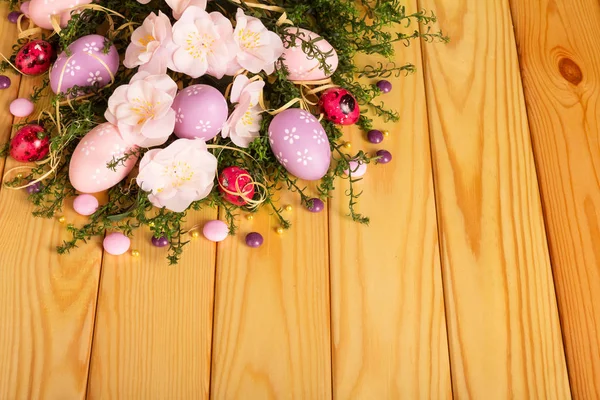 Colored easter eggs, candy, flowers, ribbon against backdrop pal — Stock Photo, Image