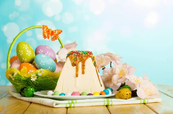 Пасхальный десерт с чизкейком, пасхальные яйца, бабочка, цветы, канд — стоковое фото