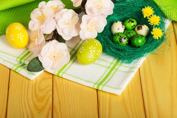 Colored Easter eggs in nest, flowers, towel and light tree. — ストック写真