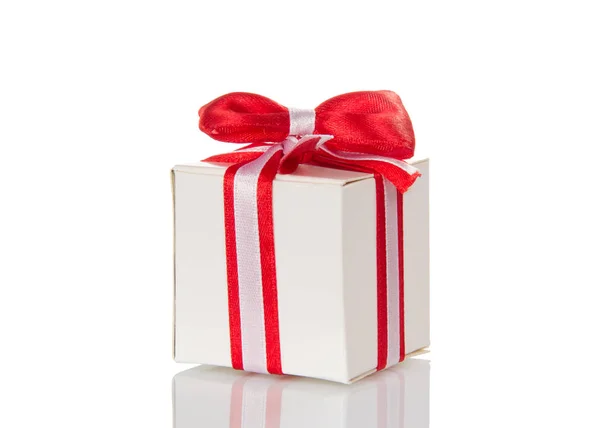 Caja de regalo blanca con cinta rayada y lazo rojo aislado — Foto de Stock