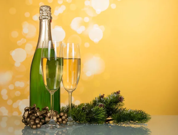 Fles champagne, twee glazen, versierde dennentakken. — Stockfoto