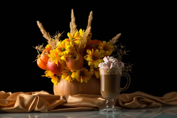 Das originelle Bouquet im Kürbis auf Seidentuch, Tasse Cappuccino mit Marshmallows isoliert auf schwarz — Stockfoto