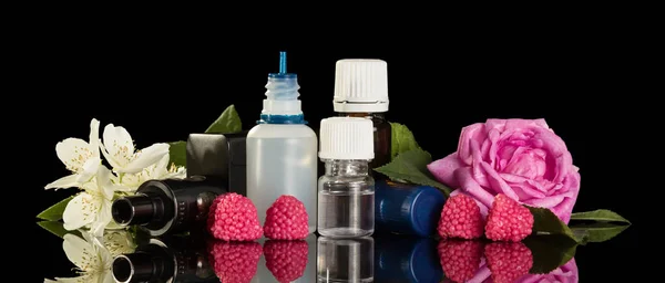 Injekční lahvičky s tekutinou pro elektronické uzení s květinovým aroma a malinami, izolované na černém — Stock fotografie