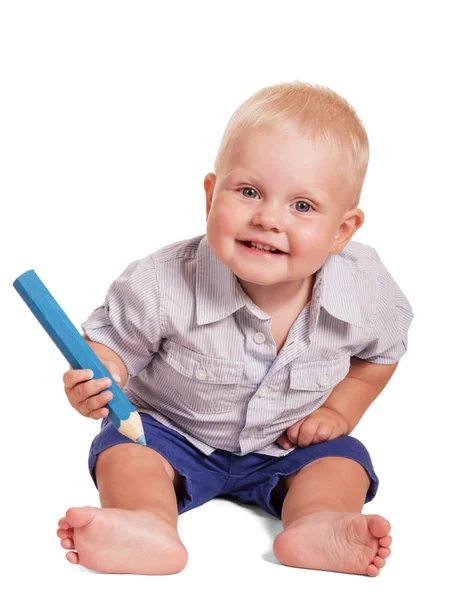 Sentado um menino adorável segura grande lápis isolado no branco . — Fotografia de Stock