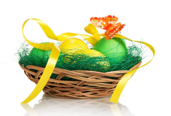 Colored Easter eggs in basket and butterfly on white background. — Stock Photo, Image