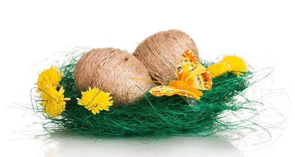 Easter eggs in nest entwined with twine, flowers and butterfly. — Stock Photo, Image