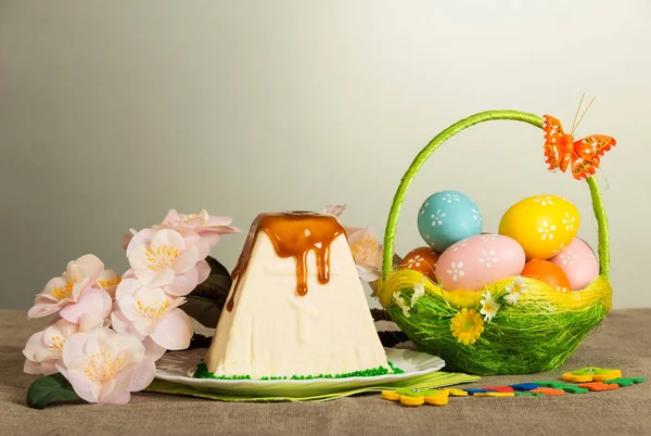 Värilliset pääsiäismunat ja perhonen, pääsiäisjuustokakku jälkiruoka — kuvapankkivalokuva