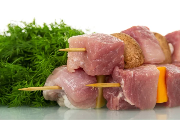 Stücke rohes Schweinefleisch, Gemüse, Pilze auf Holzspießen — Stockfoto