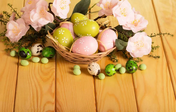 Uova di Pasqua in cesto e numero erbe, fiori, caramelle, nastro . — Foto Stock