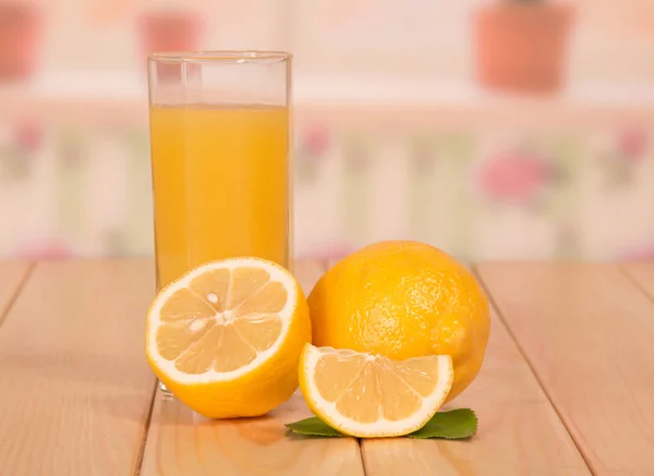 Una metà di limone matura, una fetta e un bicchiere di succo primo piano — Foto Stock