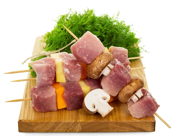 Tábua de corte, fatias de carne de porco crua, legumes e cogumelos — Fotografia de Stock