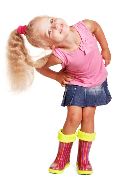 An impish little blond girl in blouse, skirt and rubber boots — 스톡 사진