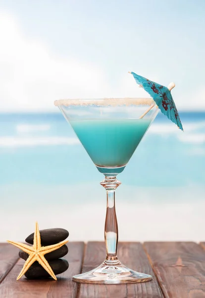 Cocktail avec parapluie, pierres lisses et étoiles de mer — Photo