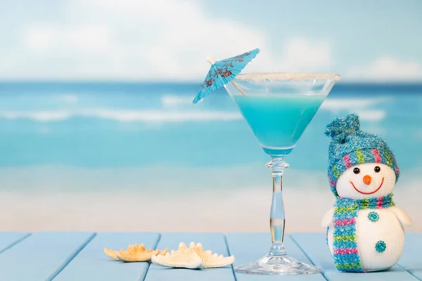 Cocktail com guarda-chuva, boneco de neve e estrela do mar em segundo plano — Fotografia de Stock