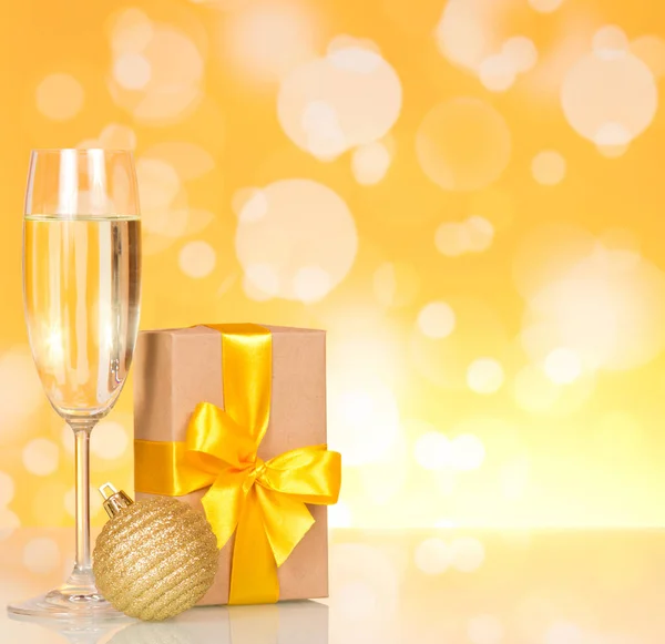 Champagner und Neujahrsgeschenk auf glitzerndem Hintergrund — Stockfoto