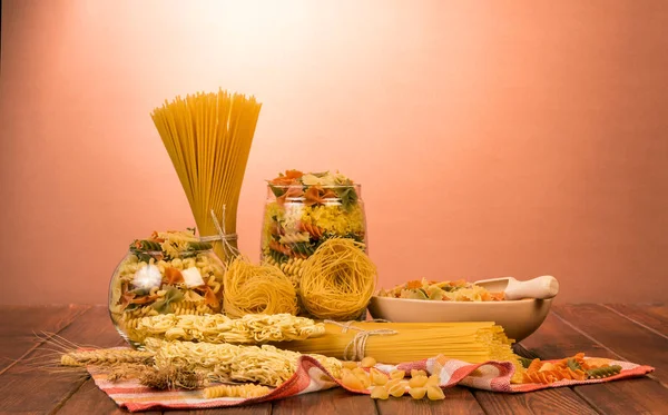Banker med olika pasta, spaghetti klasar, skål — Stockfoto
