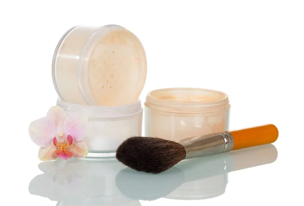 Empty open jars of powder, cosmetic brush and orchid flower — Stock Photo, Image