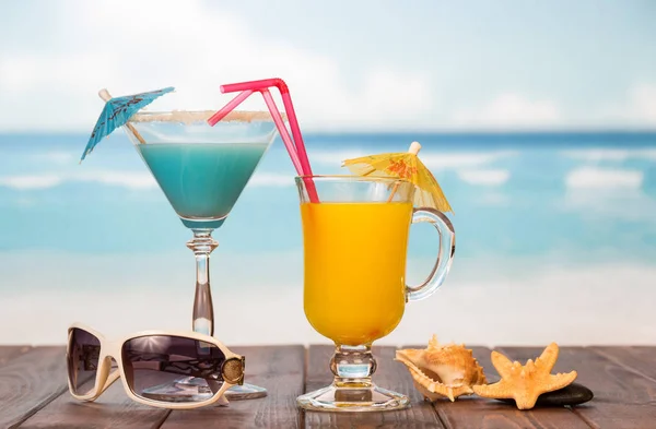Κοκτέιλ και χυμός από γυαλί με ομπρέλες, καλαμάκια, γυαλιά ηλίου — Φωτογραφία Αρχείου