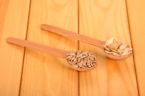 Holzlöffel mit Kürbiskernen und geschälten Sonnenblumenkernen — Stockfoto