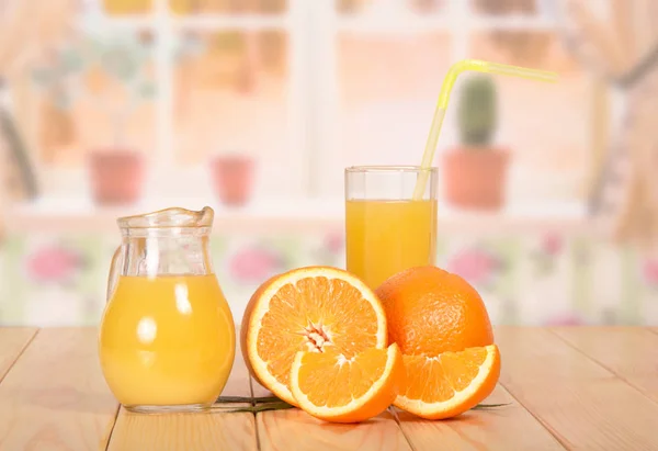 Jarra y vaso de zumo de naranja fresco con paja, naranja, mitad — Foto de Stock