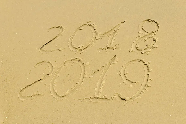 På stranden finns en inskription på sanden 2018 2019 — Stockfoto