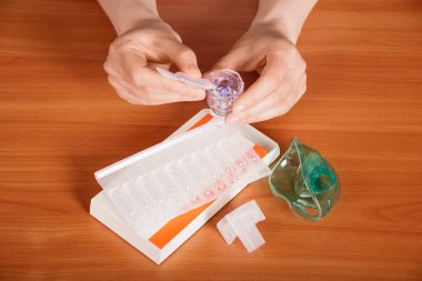 Female hands prepare a medicine for inhalation