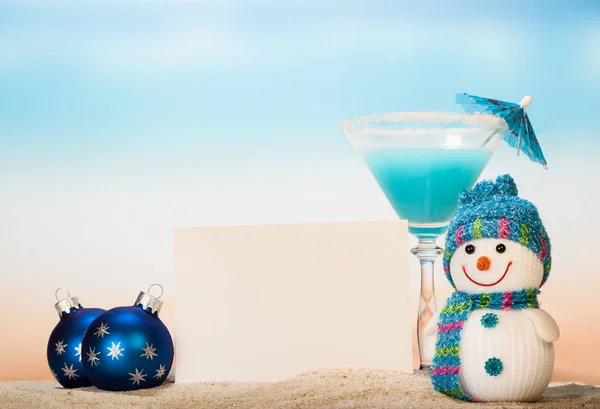 Коктейль с зонтиком, снеговиком, чистая открытка и рождественские шары — стоковое фото