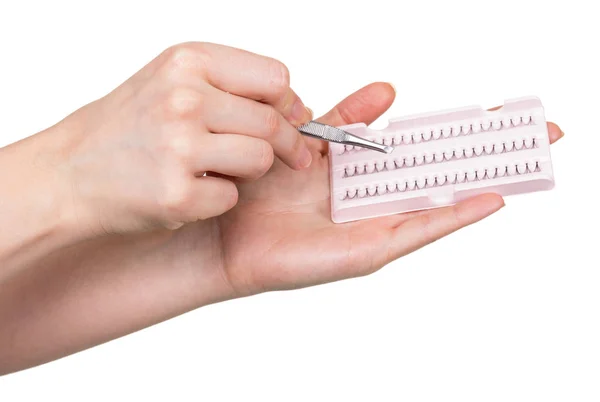 Set of false eyelashes bunches and tweezers in female hands — Stock Photo, Image