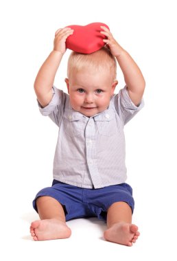 Charming baby holding a red heart in hands over head, isolated on white background