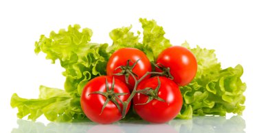 Tomatoes and fresh green lettuce leaves isolated on white.