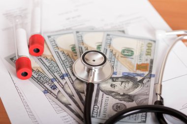 Tanı için fonendoskop ve test tüpü, masada para