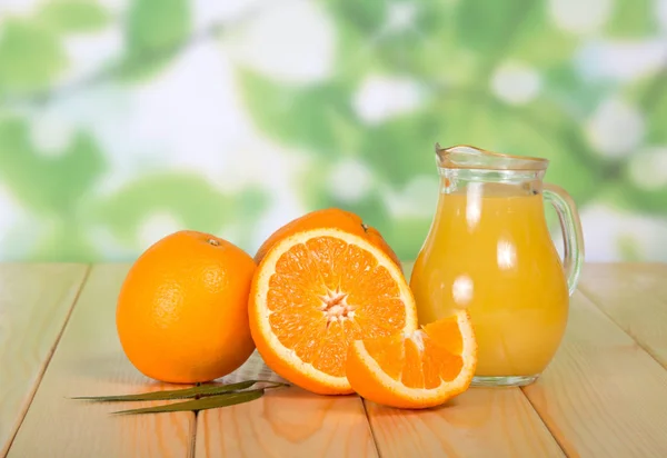Een Volle Kan Sap Hele Sinaasappels Stukjes Fruit Houten Tafel — Stockfoto