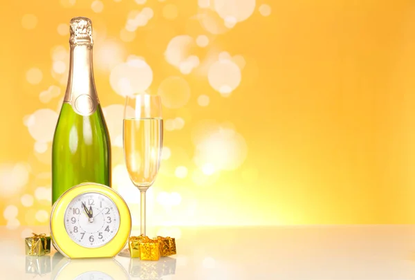 Fles Met Champagne Kleine Nieuwjaarsverrassingen Klok Gele Achtergrond — Stockfoto