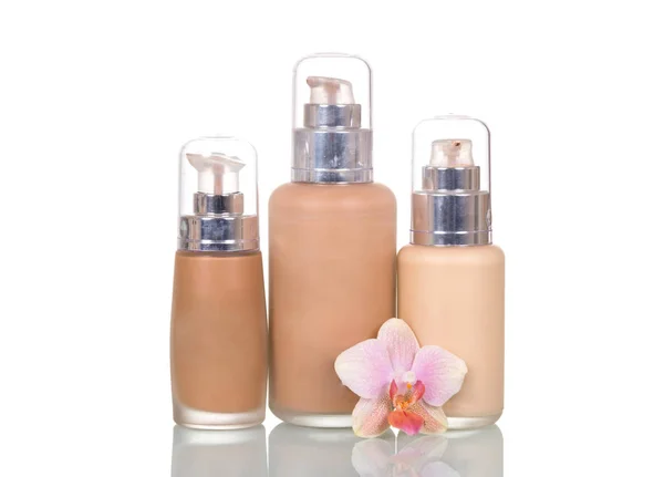 Bottles with foundation of various tones and an orchid flower — Stockfoto