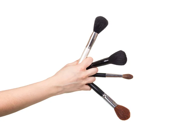 Four cosmetic brushes in female hand isolated on white — Stok fotoğraf